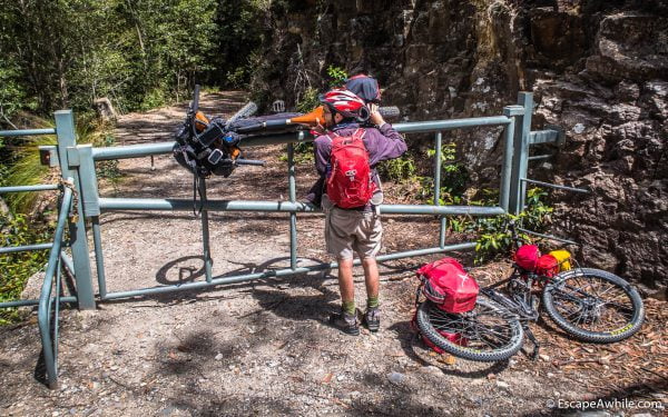Wrestling bikes over the locked gates on the Griffiths fire trail